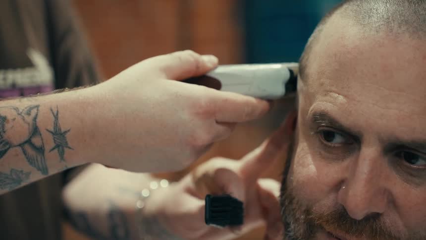 Man having his hair cut with a clipper in a barber shop