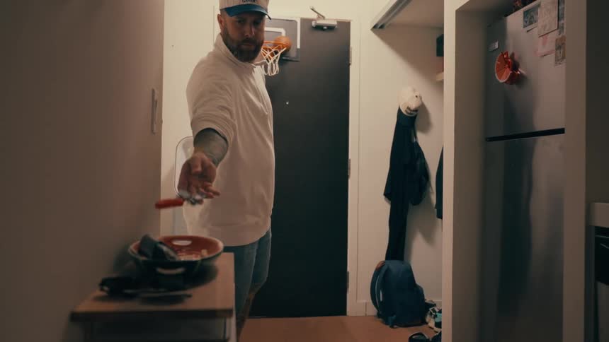 Man throwing a key into a container above a counter
