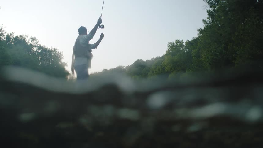 View of a man from behind fishing in a river