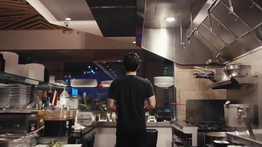 View of the inside of a kitchen and a man standing with his back turned