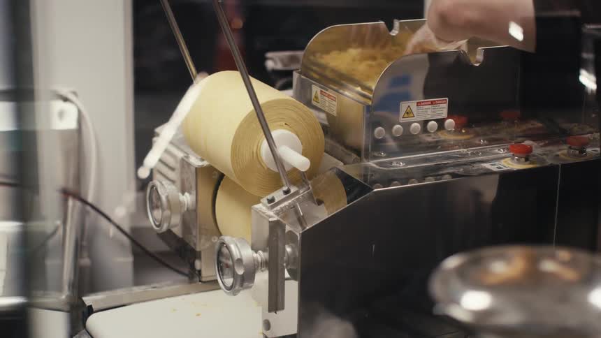A man is mixing dough in a machine