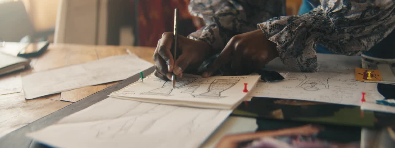 Hands of a fashion designer designing a dress