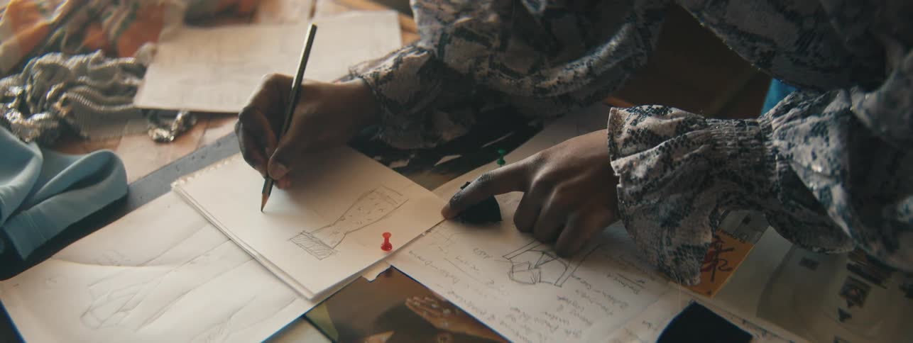 Womans hands on the table drawing on a white sheet