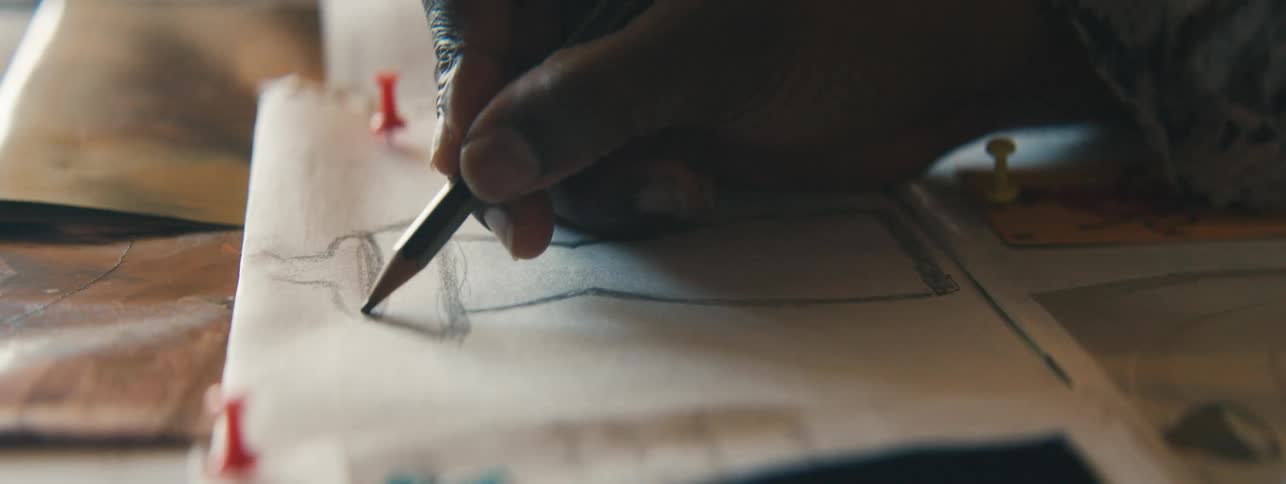 A person is drawing with a pencil on paper