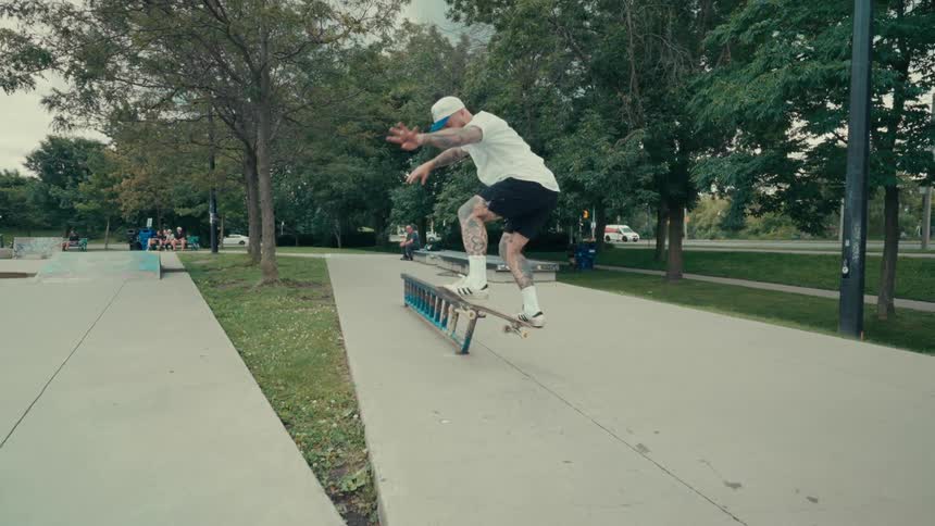 Man in a public square doing a very difficult trick with a skateboard