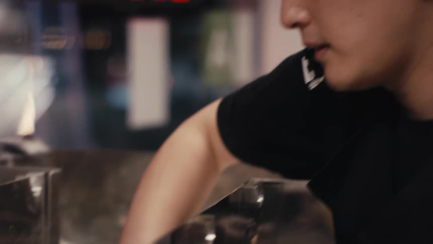 Young man in a restaurant using a pasta machine