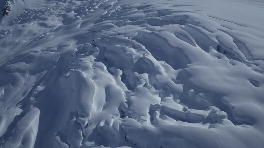 Vast snowcovered landscape features gentle glacier formations shaped by wind and ice movement