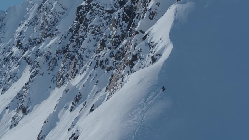 Aerial view of a person climbing a snow covered mountain