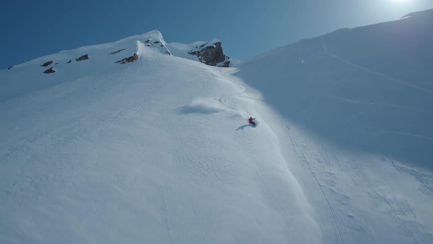 A man is skiing down a tall mountain