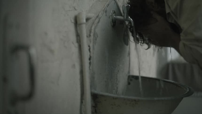 A close up clip of a person drinking water from a tap
