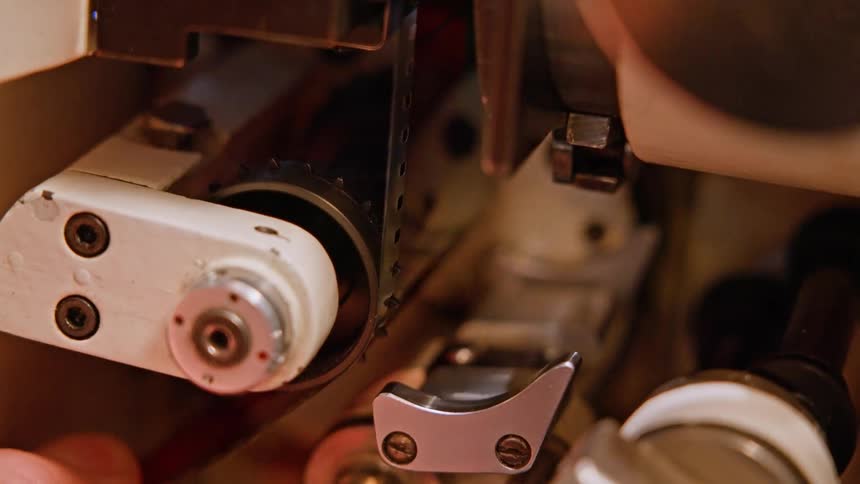A person puts film in the projector