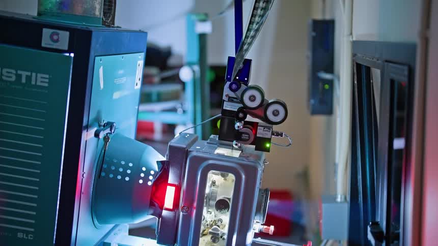 Filmstrip moves through a projector in the projection booth