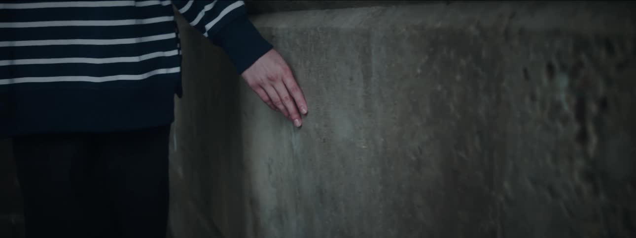 Womans hand leaning against the wall while walking