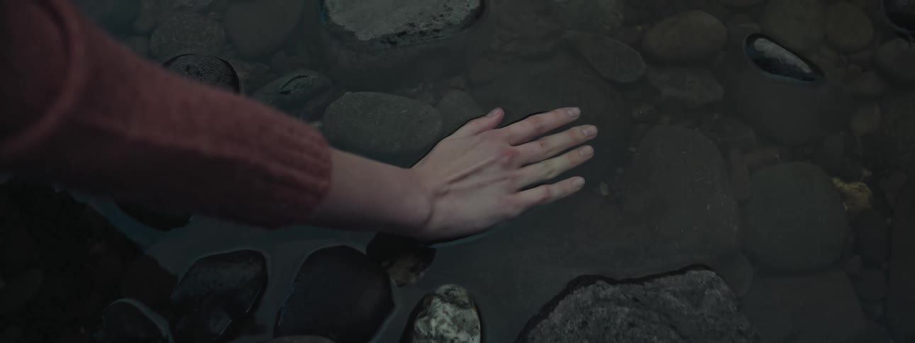 A womans hand in a small rock puddle