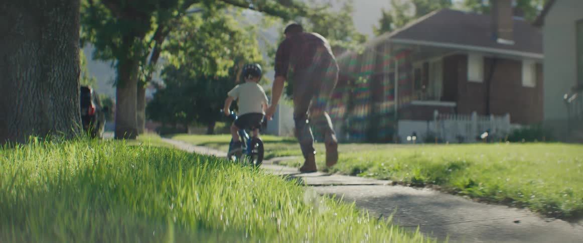Father accompanying his little son riding a bicycle