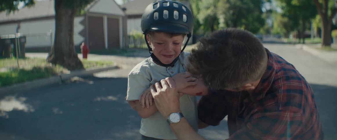 Father checking his sons arm for injury while he cries