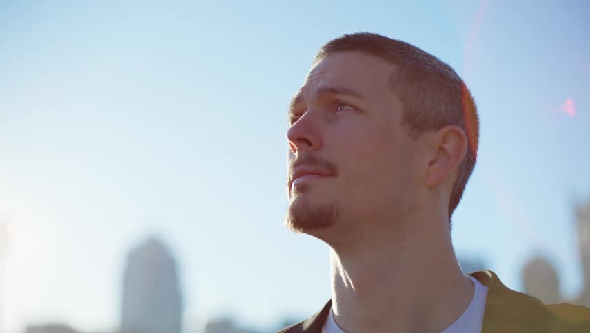 Portrait of a bearded man looking around with sun reflection