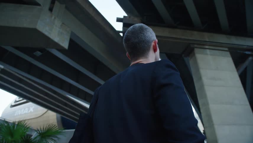 A man is gazing up under the overpass