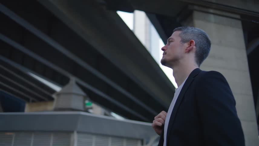 A man stands outside staring at a huge building in front of him