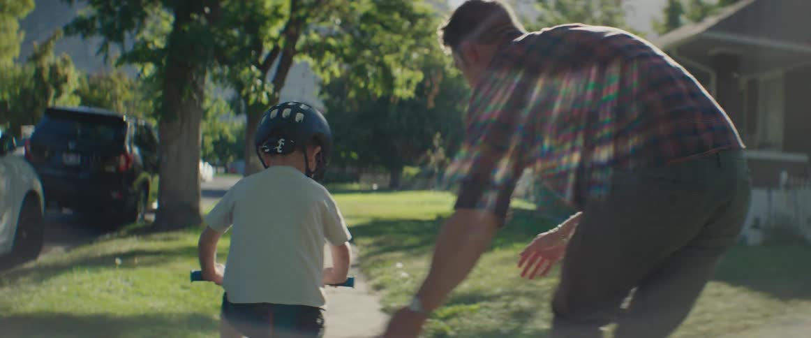 A father is teaching his son how to ride a bike