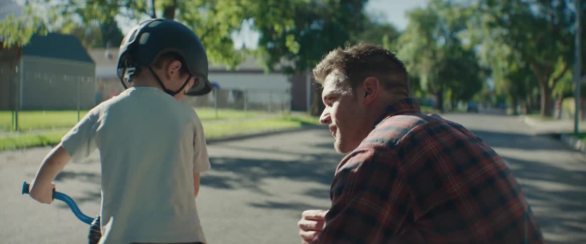 A clip of a father and son learning how to ride bicycle on the street