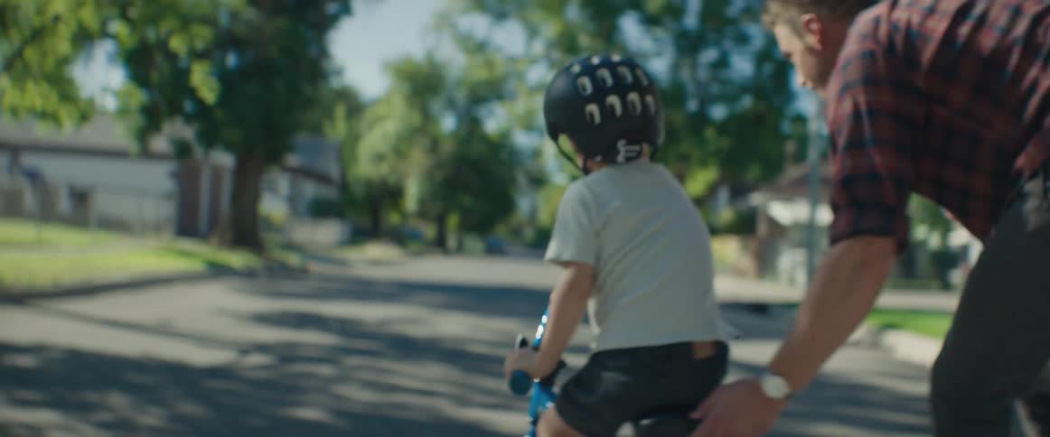 Man helping a child ride a bike