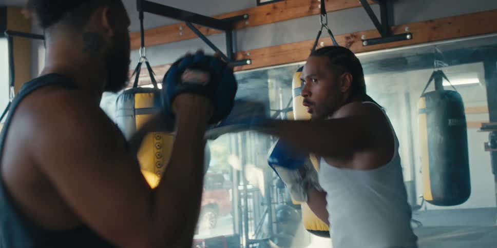 Two men practicing boxing moves in a gym