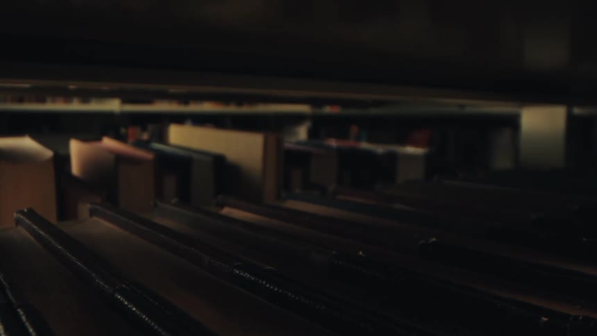 Rows and rows of books sit on shelves in a library
