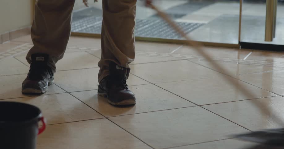 Person with a squeegee mopping a wet floor