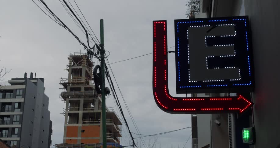 Led sign on a building near an unfinished building blinks on an overcast day