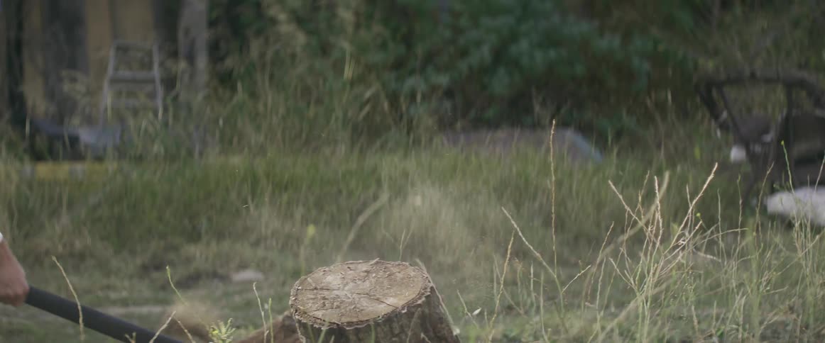 A person using an axe to chop wood