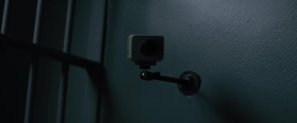 Infrared security camera flashing on the wall of a dark room