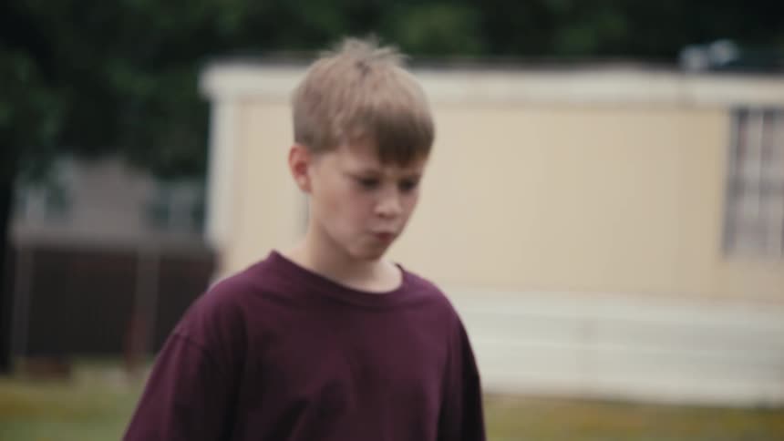 A clip of a boy eating and walking