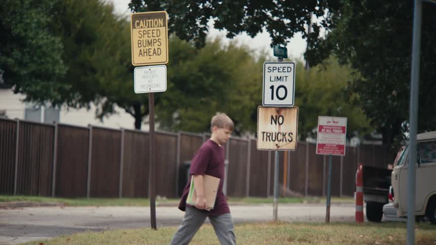 A clip of a young boy walking by the roadside