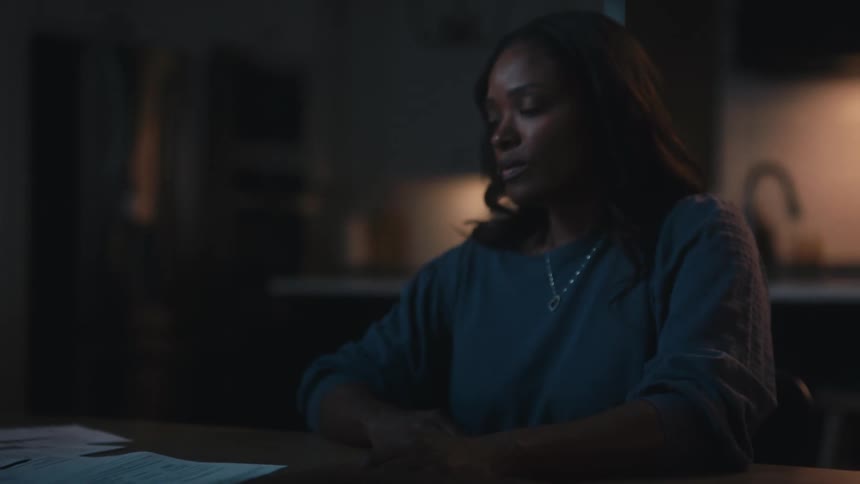 Woman sitting at the table picking up a book