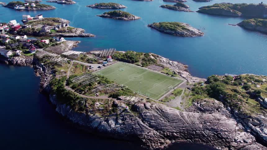 An aerial view of a small island with a soccer field in the center