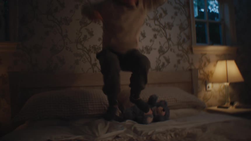 Boy having fun while jumping on the bed