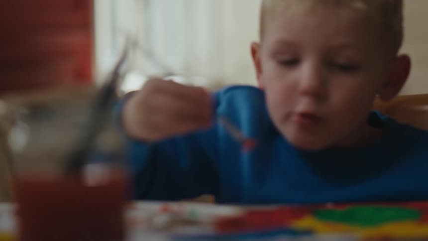 A young boy paints a picture