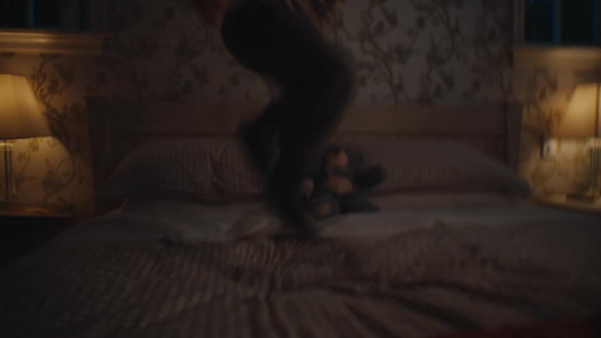 Boy playing alone jumping on the bed