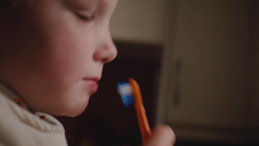 A young boy brushes his teeth