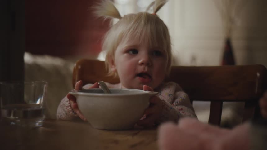 A girl is having a bowl of cereal at home