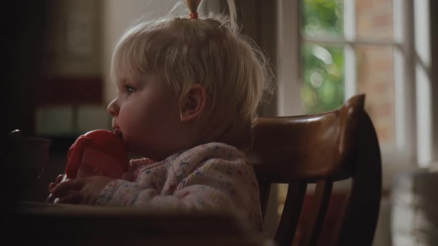 A child is drinking from a sippy cup
