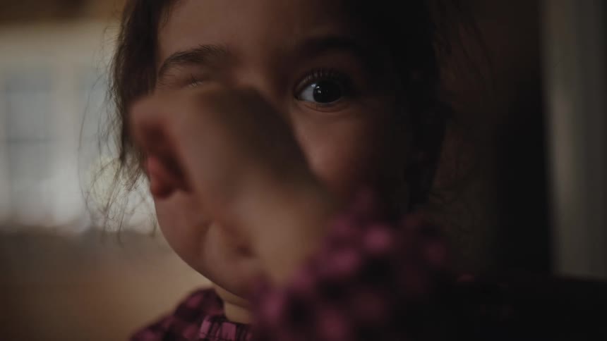 Portrait of a little girl with a small spoon eating