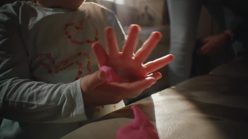 Hand of a small child playing with modeling clay