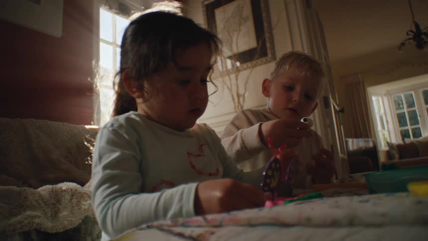 Two small children in the living room playing with toys