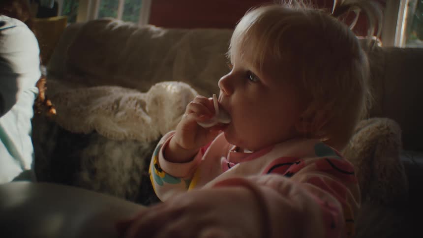 Little girl putting pacifier in her mouth