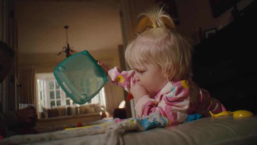 Two small children playing with toys in a room of the house