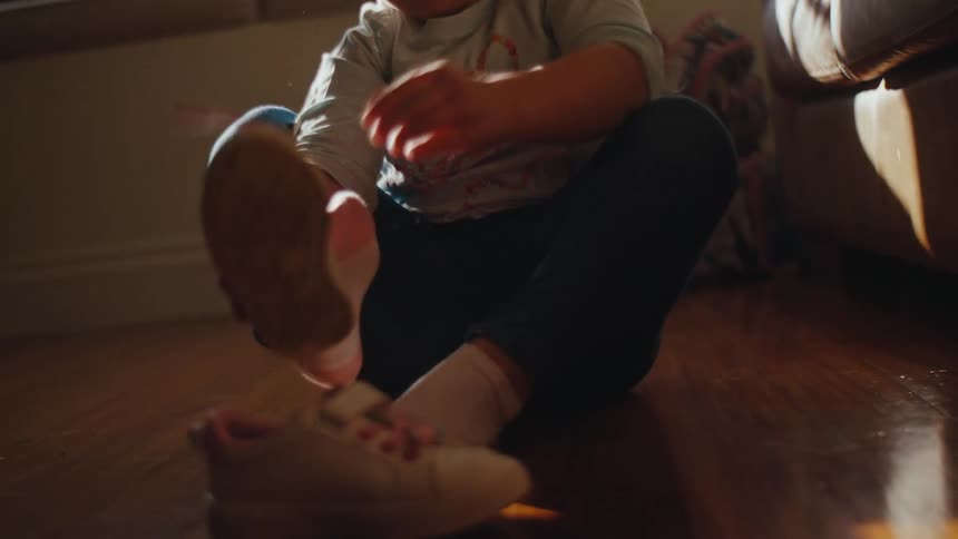 Small child trying to put on sneakers