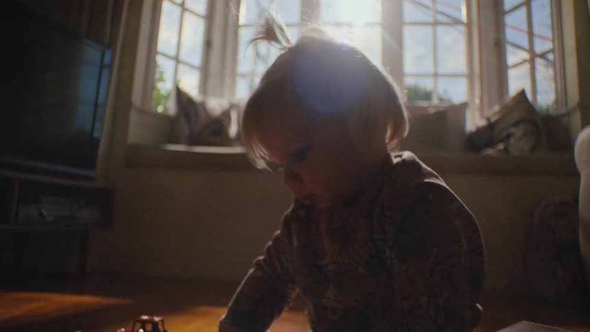 Small child sitting on the floor playing with toys