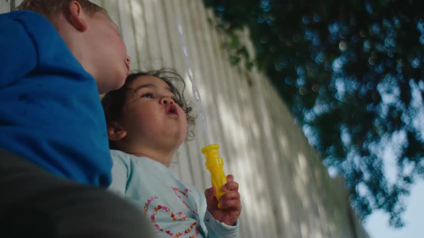 Two children bubbles outside